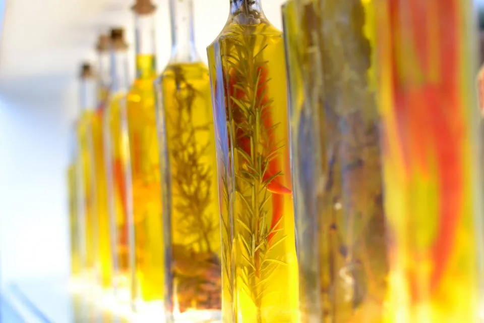 A row of glass bottles of herb-infused oil